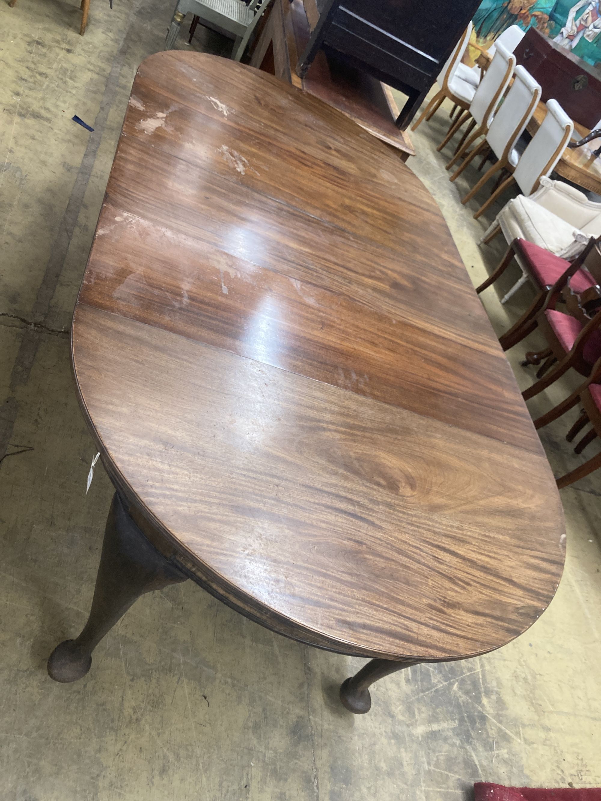A 1920's circular mahogany extending dining table with three leaves and handle, length approx. 230cm extended, width 120cm, height 75cm